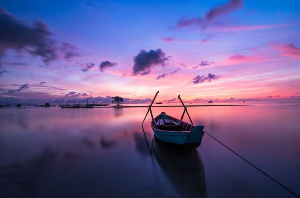 Ruderboot im Meer beim Sonnenaufgang Sonnenaufgang am Meer