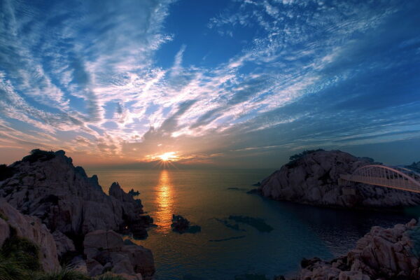Wolken fotografieren beim Sonnenaufgang am Meer – beeindruckende Lichtstimmung Sonnenaufgang über dem Meer mit leuchtenden Wolken und Felsen – ideal zum Wolken fotografieren in stimmungsvoller Küstenlandschaft