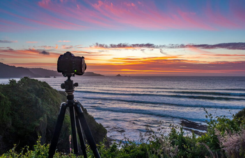 Kamera auf Stativ bei Sonnenuntergang an der Küste für Landschaftsfotografie
