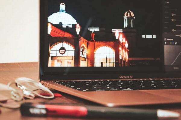 Architekturfotografie: Nachbearbeitung von Gebäudefotos am Laptop Nachbearbeitung in der Architekturfotografie am Laptop mit geöffnetem Bildbearbeitungsprogramm