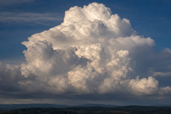 Wolken mit längerer Brennweite fotografieren Mächtige Wolkenformation mit Teleobjektiv über einer Landschaft