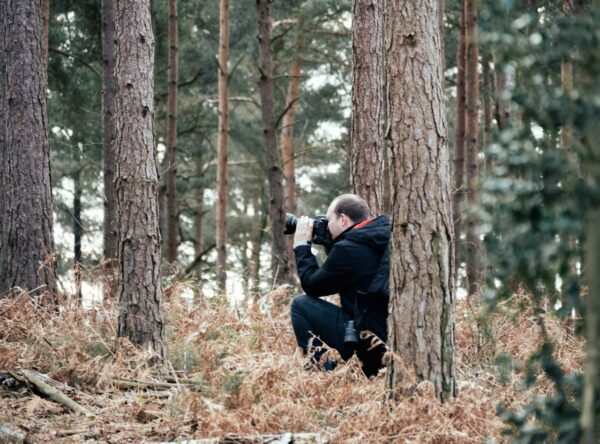 Fotograf im Wald mit Kamera – Naturfotografie mit Geduld und Achtsamkeit