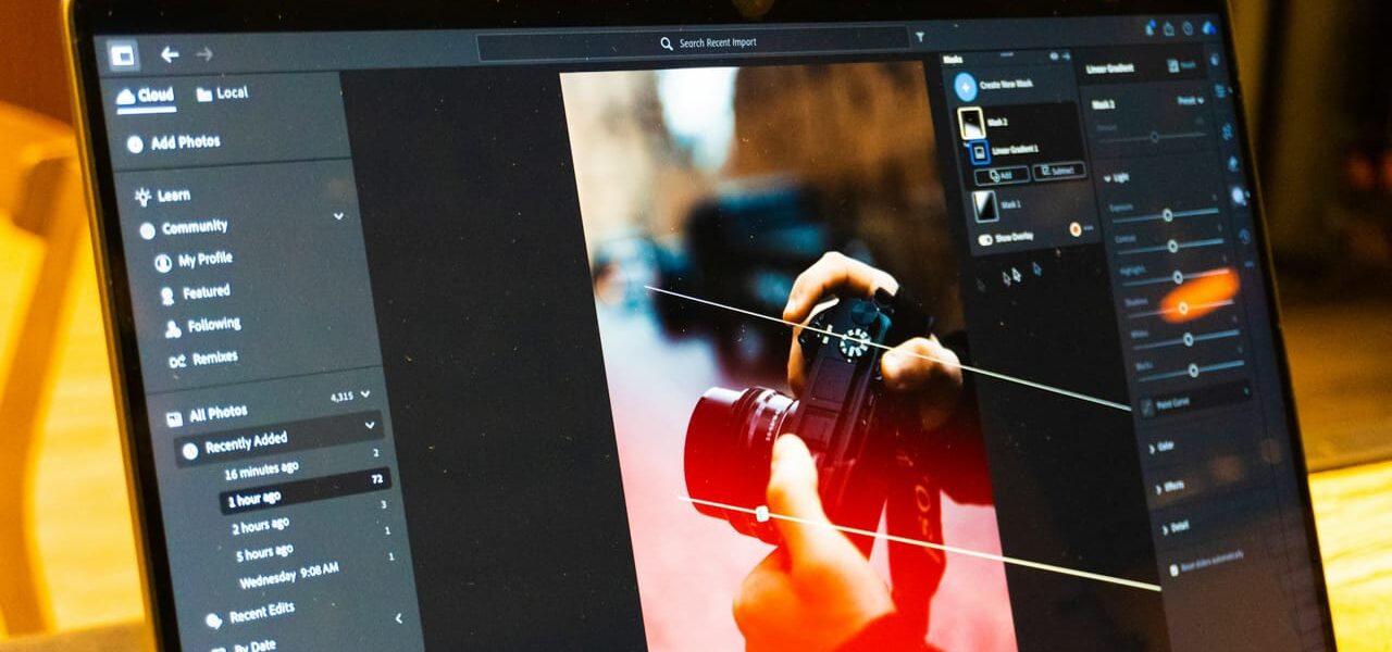 Laptop mit geöffneter Bildbearbeitungssoftware beim Fotos nachbearbeiten