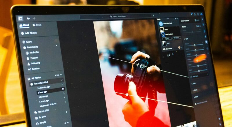 Laptop mit geöffneter Bildbearbeitungssoftware beim Fotos nachbearbeiten