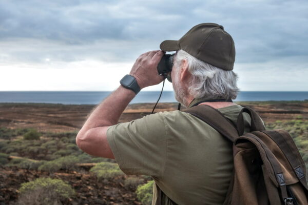 Den fotografischen Blick mit dem Fernglas schärfen Blick durch ein Fernglas auf eine neblige Gebirgskette zur Motivsuche